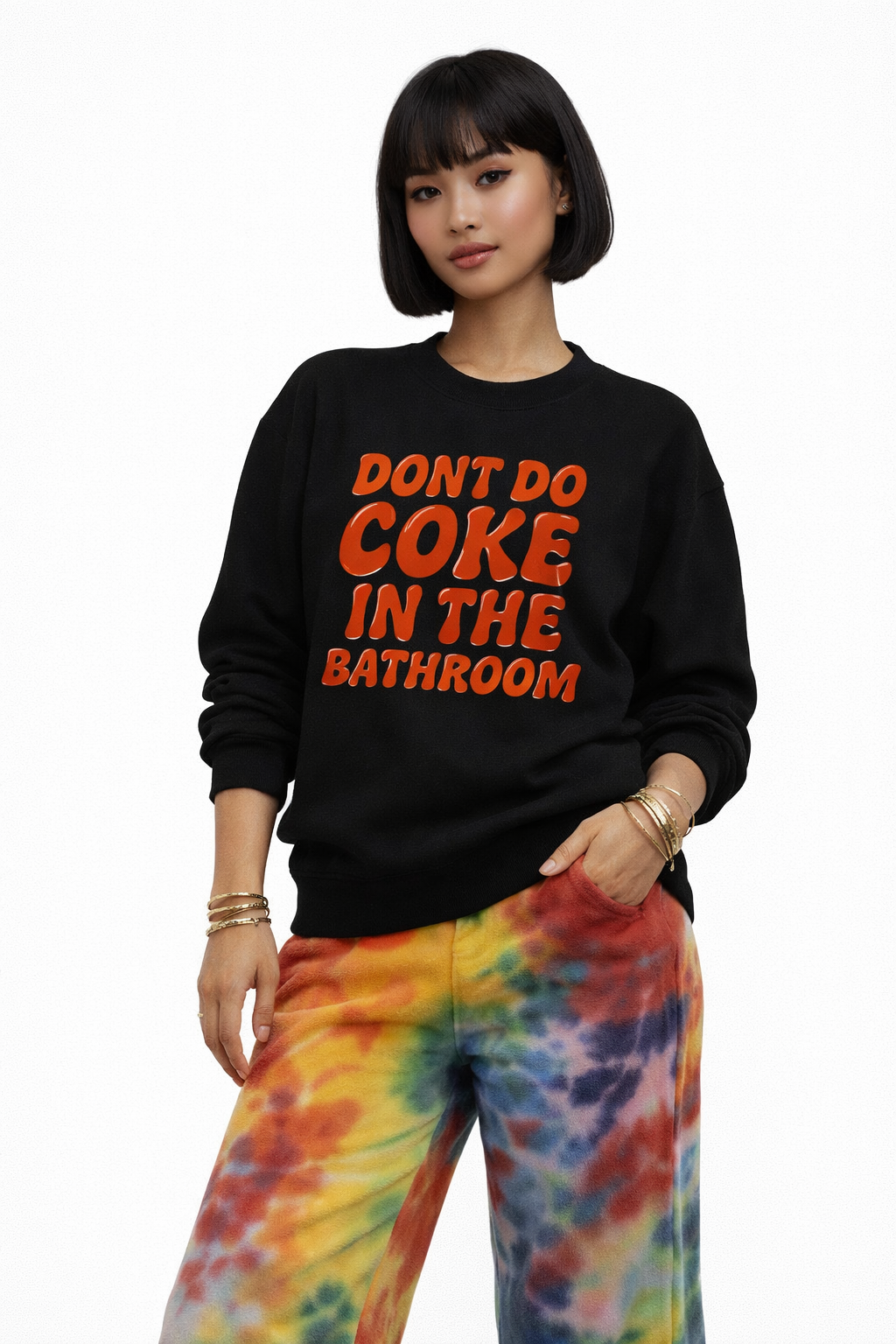 Person wearing a black sweatshirt with red text and tie-dye pants on a white background